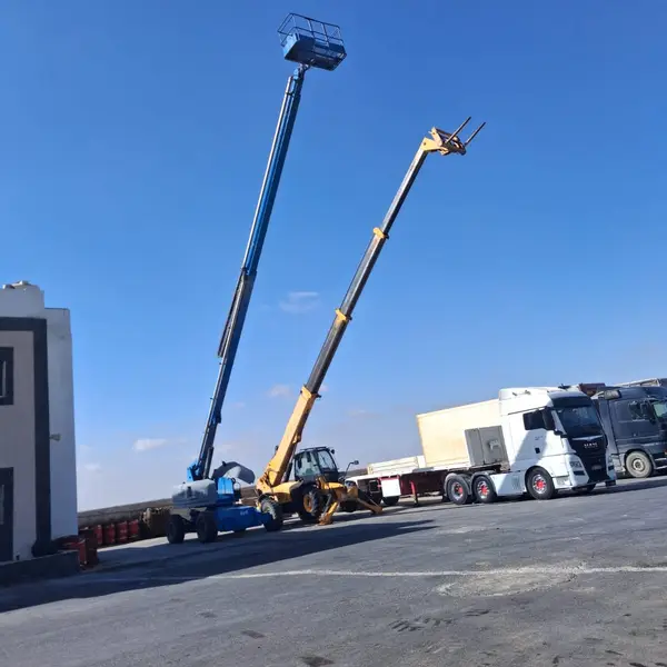 Telehandler and boom lift working alongside project trucks